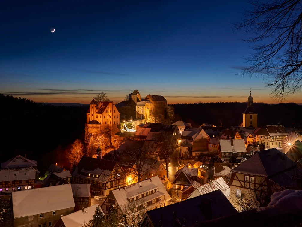 Burg Hohnstein im Winter Burg Hohnstein thront im winterlichen Abendlicht über dem verschneiten, festlich beleuchteten Ort.