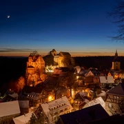 Burg Hohnstein im Winter Burg Hohnstein thront im winterlichen Abendlicht über dem verschneiten, festlich beleuchteten Ort.