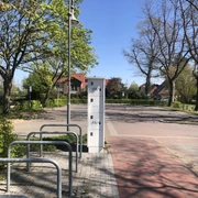 eBike Ladestation am Kögel-Willms-Platz Fahrradständer und Aufbewahrungsboxen an einem ruhigen Platz mit Bäumen und blauem Himmel