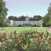 Park Klinik_Signature.jpg Die Parkklinik mit ihrer klassischen Architektur steht hinter bunten Blumen und Grünflächen.