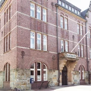 Backsteinrathaus auf Borkum mit großen Fenstern und markantem Eingangsbereich.Brick town hall on Borkum with large windows and a prominent entrance.