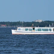 Schaumburg-Lippe auf dem Steinhuder Meer Ein weißes Passagierschiff fährt auf dem ruhigen Steinhuder Meer entlang, im Hintergrund Segelboote.