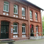 Tourist-Info Stolzenau Ziegelsteingebäude mit weißen Fensterrahmen, Fahrradständer vor dem Eingang und Tourist-Informationsschild.