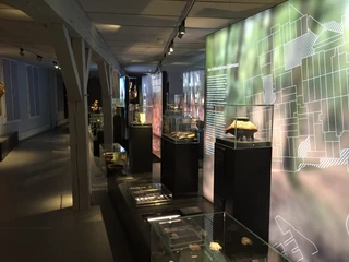 Altsachsengräber Liebenau - Ausstellungsstücke im Regionalmuseum Nienburg Ausstellung in einem Museum mit beleuchteten Vitrinen, die prähistorische Artefakte präsentieren.