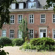 Amtshof 2 Bruchhausen-Vilsen Ein rotes Backsteingebäude mit vielen Fenstern, umgeben von Grün, bildet den Amtshof in Bruchhausen-Vilsen.