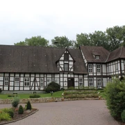 Amtshof Steyerberg Fachwerkgebäude des Amtshofs Steyerberg mit gepflasterter Einfahrt und umgebenden Bäumen im Hintergrund.