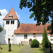 Kirche Heimsen Eine weiße Kirche mit rotem Ziegeldach, umgeben von Rasen und Bäumen, im historischen Stil.
