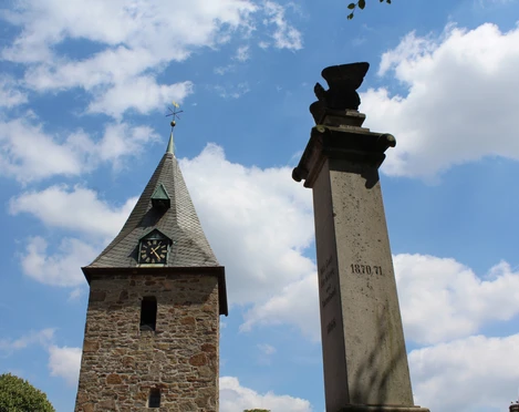 Kirche Schlüsselburg Historische Kirche mit einem steinernen Turm und nicht weit entfernt befindet sich ein Denkmal.