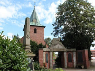 Marienkirche Leeste Marienkirche Leeste mit rotem Klinkerturm, spitzem grünen Dach und umliegender Begrünung.