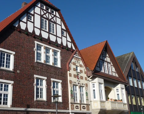 Riekes Honigkuchenfassade Fachwerkhaus mit verzierten Klinkerfassaden und Holzdetails vor blauem Himmel in Niedersachsen.
