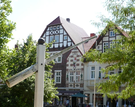 Riekes Honigkuchenfassade Fachwerkhäuser mit roten Dächern und filigranen Verzierungen an einem sonnigen Marktplatz.