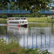 Die FGS Bremen in Nienburg Das Fahrgastschiff Bremen passiert die Weserbrücke bei Nienburg auf einem grünen, ruhigen Fluss.