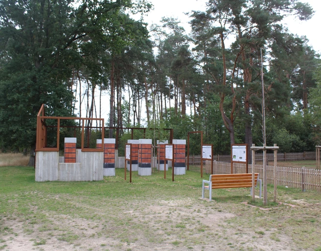 Gedenkstätte Heemsen Gedenkstätte in Heemsen mit Informationstafeln vor einem bewaldeten Hintergrund und einer Sitzbank.