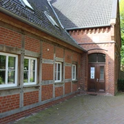 Heimatstube Schweringen Fachwerkgebäude mit roten Ziegeln und weiß eingerahmten Fenstern in ländlicher Umgebung.