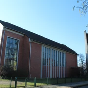 St. Bernwardkirche Backsteinkirche mit großen Fenstern und freistehendem Glockenturm, markant durch das Kreuz.