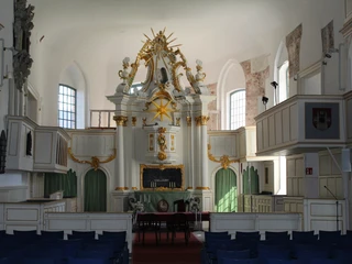 Historische Innenansicht der Martinskirche mit kunstvoll verzierten weißen und goldenen Elementen.
