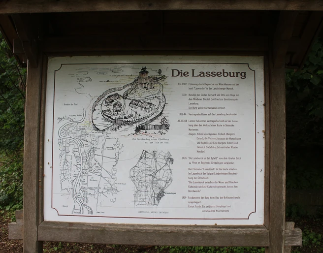 Landesbergen Lasseburg Schild mit Lageplan und Historie der Lasseburg in Landesbergen, umgeben von üppigem Grün.