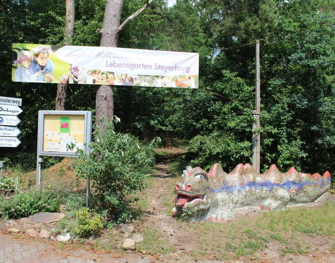 Lebensgarten Steyerberg Ein farbenfroher Keramikdrache begrüßt Besucher am Eingang des Lebensgarten Steyerberg.