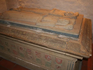 Sarkophag der Grafen von Hoya Sarkophag aus Sandstein mit liegenden Figuren und detailreicher Inschrift in einer alten Kapelle.