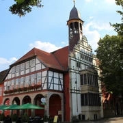 Rathaus Nienburg Historisches Rathaus Nienburg mit markantem Glockenturm, Fachwerkfassade und bunter Außengastronomie.
