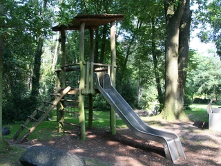 Rathauspark Achim Rathauspark Achim: Spielplatz mit Holzklettergerüst, Rutsche und grüner Umgebung; kinderfreundlich.