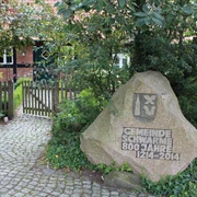 Robberts Huus Vor einem Backsteinhaus steht ein geschmückter Stein zum 800-jährigen Bestehen der Gemeinde Schwarme.