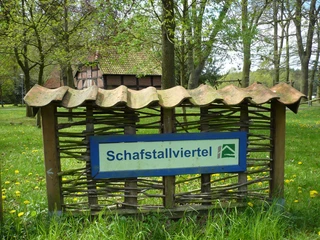 Schafstallviertel Hülsen Hinweis auf das Schafstallviertel Hülsen, umgeben von grüner Wiese und ländlicher Kulisse.