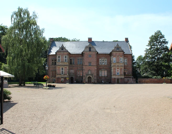 Schloss Erbhof Thedinghausen Historisches Schloss Erbhof Thedinghausen mit Backsteinfassade und großzügigem Vorplatz im Sommer.