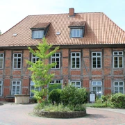 Schöne Reihe 20 Bruchhausen-Vilsen Ein traditionelles Fachwerkgebäude mit roten Ziegeln in Bruchhausen-Vilsen, umgeben von Grün.