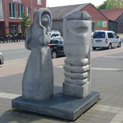 Zwei moderne Steinskulpturen symbolisieren den Hör- und Geschmacksinn auf einem öffentlichen Platz.