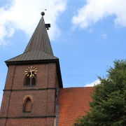 St. Aegidien-Kirche Rodewald Backsteinkirche mit markantem Kirchturm und Uhr in grüner Umgebung unter blauem Himmel.