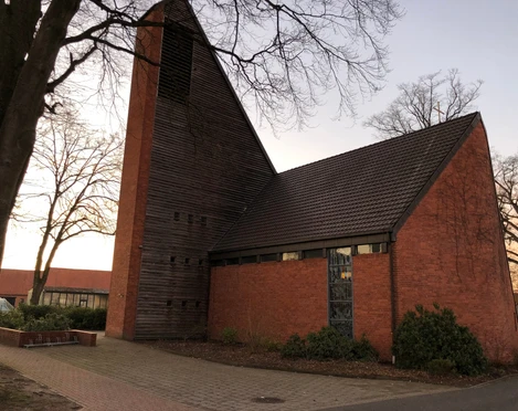 St. Marien Kirche Haßbergen Backsteingebäude mit steilem Holzturm und Fenstern, umgeben von kahlen Bäumen und gepflastertem Weg.