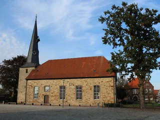 St. Martini-Kirche in Rehburg, ein romanisches Bauwerk mit einem markanten Turm und roten Ziegeldach.