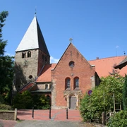 St.-Clemens-Romanus-Kirche in Marklohe, rot verklinkert mit markantem Kirchturm und grüner Umgebung.
