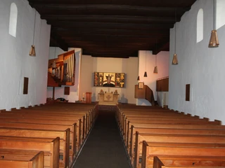 St.-Gangolf-Kirche in Wietzen Innen Innenansicht der St.-Gangolf-Kirche Wietzen mit Holzbänken und einem Altar im Mittelpunkt des Raumes.