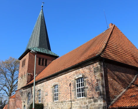 St.-Martin-Kirche Holtorf St.-Martin-Kirche in Holtorf mit markantem roten Ziegeldach und hohem, spitzem Kirchturm.