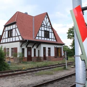 Südbahnhof Weyhe Ein historisches Fachwerkgebäude steht neben Gleisen unter einem wolkigen Himmel am Südbahnhof Weyhe.