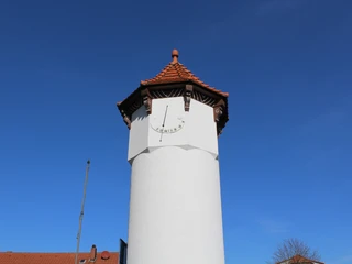 Stadt Rehburg-Loccum Uhrturm Uhrturm in Rehburg-Loccum mit giebelrotem Ziegeldach vor strahlend blauem Himmel.
