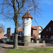 Stadt Rehburg-Loccum Uhrturm Der historische Uhrturm von Rehburg-Loccum mit rotem Ziegeldach, umgeben von Bäumen und Wohnhäusern.