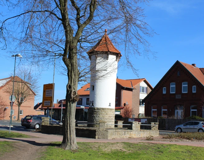 Stadt Rehburg-Loccum Uhrturm Der historische Uhrturm von Rehburg-Loccum mit rotem Ziegeldach, umgeben von Bäumen und Wohnhäusern.