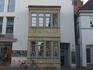 Renaissance-Erker Ein aufwendig verzierter Renaissance-Erker mit fünf Fenstern und kunstvollen Steinreliefs an der Fassade.