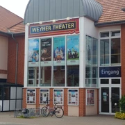 Weyher Theater Weyher Theater mit roter Backsteinfassade, Plakaten aktueller Stücke und Eingangsbereich.