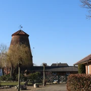Mühle Nienburg-Erichshagen Historische Windmühle mit Backsteingebäuden im strahlenden Sonnenschein eines klaren Tages.