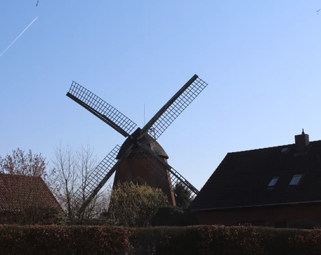 Windmühle im Nienburger Leintor Windmühle mit markanten Flügeln und Backsteinbauten im Vordergrund unter blauem Himmel in Nienburg.