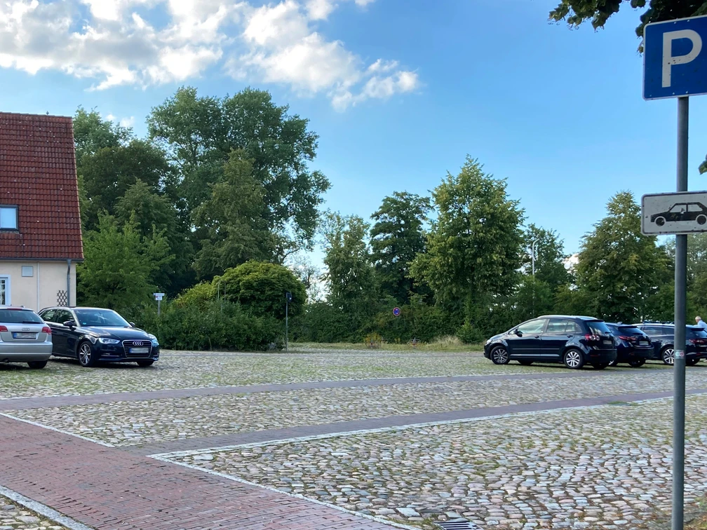 Parkplatz_MoellnerStr1_22082023_PetraRoemer.jpg Parkplatz mit Stellflächen, geparkten Autos und Hinweisschildern