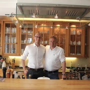 WEB1.JPG Innenraum der Villa Martha, zwei Männer stehen hinter der Theke, Einrichtung und Dekoration sichtbar