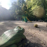 Spielplatz Marienweg - Familienurlaub in Leipzig Schattiger Spielplatz, der an ein Schloss erinnert mit hölzernem Froschkönig.