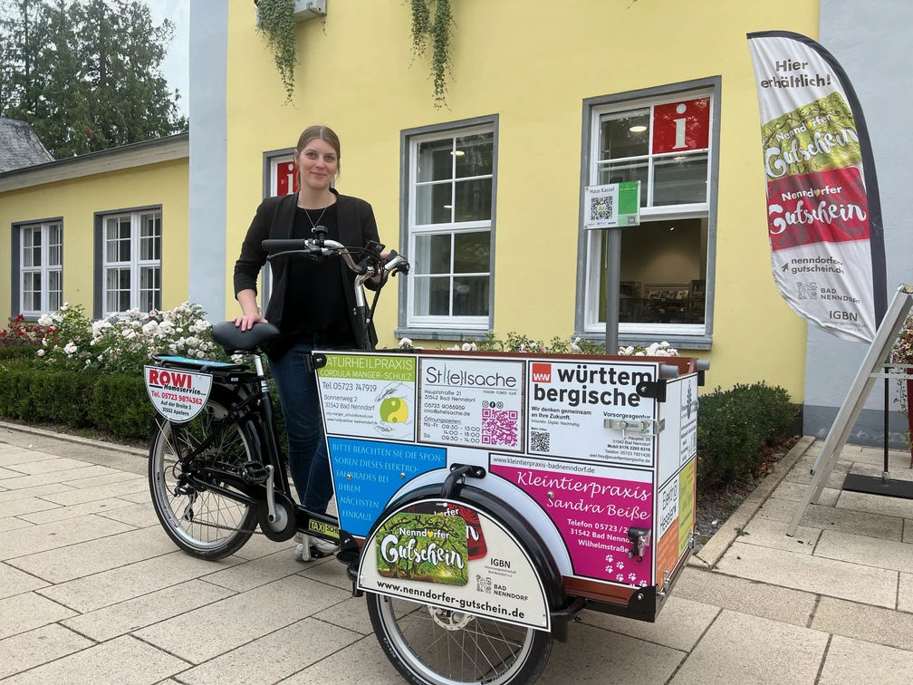 Lastenrad Babboe Ein Lastenrad von Babboe mit Werbeaufdruck vor einem gelben Gebäude in Bad Nenndorf.