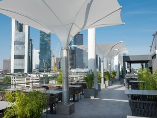 Stühle und Tische auf der Terrasse mit Blick auf die SkylineChairs and tables on the terrace overlooking the skyline