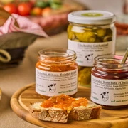 Herzhafte Aufstriche von Gut Ellscheid, Haan Verschiedene Gläser mit hausgemachten Aufstrichen und Chutneys auf einem Tisch mit rustikalem Brot.